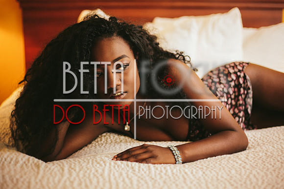 Beautiful young black woman in lingerie lying on bed